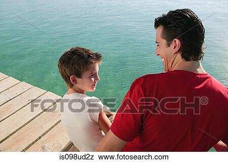 Father and son on a jetty by the sea View Large Photo Image Stock Photo - Father and son on a jetty by the sea. Fotosearch