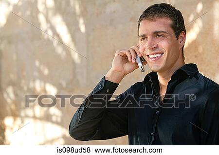 Man in a black shirt using cellphone View Large Photo Image Stock Photo - Man in a black shirt using cellphone. Fotosearch