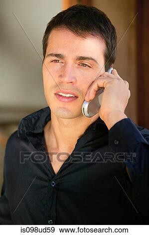 Man in a black shirt using cellphone View Large Photo Image Stock Photo - Man in a black shirt using cellphone. Fotosearch