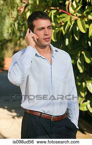 Stock Photograph - Man using cellphone outdoors. Fotosearch