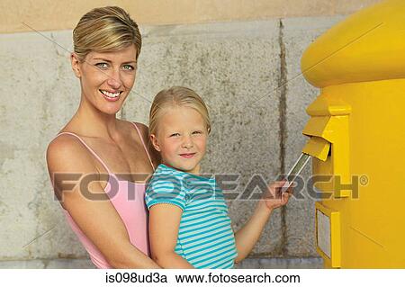 Stock Image - Mother and daughter at postbox. Fotosearch