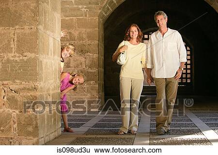 Parents walking and children behind pillar View Large Photo Image Stock Photograph - Parents walking and children behind pillar. Fotosearch