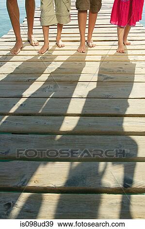 Shadows of family on a jetty View Large Photo Image Stock Photo - Shadows of family on a jetty. Fotosearch