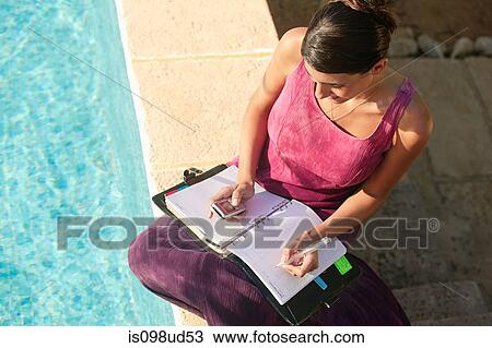 Woman by swimming pool with cellphone and organizer View Large Photo Image Stock Image - Woman by swimming pool with cellphone and organizer. Fotosearch