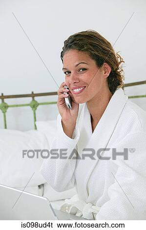 Woman in bathrobe with cellphone and laptop View Large Photo Image Stock Photograph - Woman in bathrobe with cellphone and laptop. Fotosearch