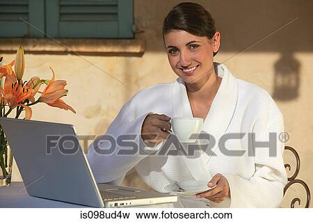 Woman in bathrobe with coffee and laptop View Large Photo Image Stock Photo - Woman in bathrobe with coffee and laptop. Fotosearch