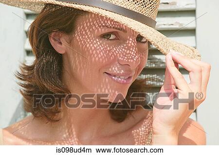 Woman wearing a sun hat with shadows on face View Large Photo Image Picture - Woman wearing a sun hat with shadows on face. Fotosearch
