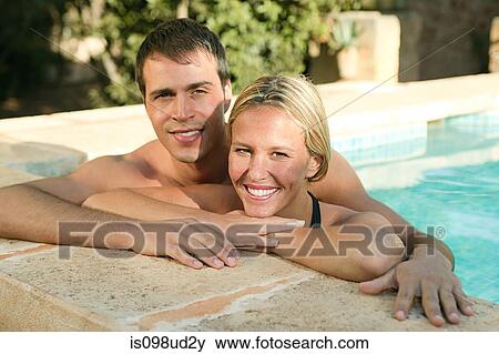 Stock Photo - Young couple in swimming pool. Fotosearch