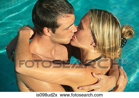 Stock Photo - Young couple kissing in swimming pool. Fotosearch