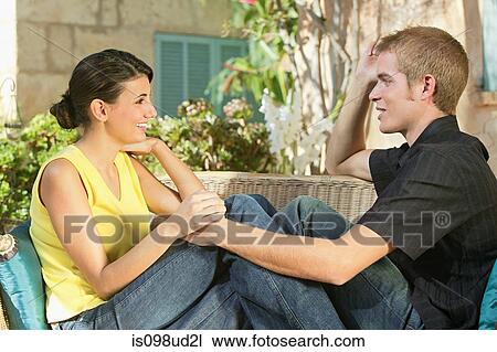 Young couple sitting together on a seat View Large Photo Image Stock Image - Young couple sitting together on a seat. Fotosearch