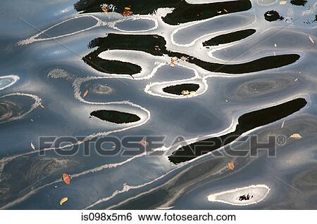Stock Photograph - Ripples and reflections on water surface. Fotosearch