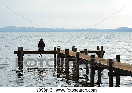 Woman sitting on a jetty View Large Photo Image Stock Image - Woman sitting on a jetty. Fotosearch