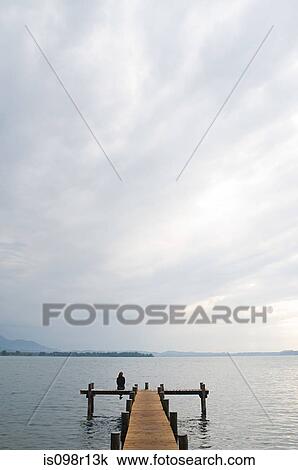 Woman sitting on a jetty View Large Photo Image Stock Image - Woman sitting on a jetty. Fotosearch