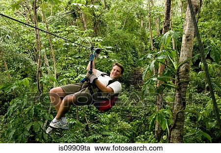 Stock Image - Adventurer on zip line. Fotosearch
