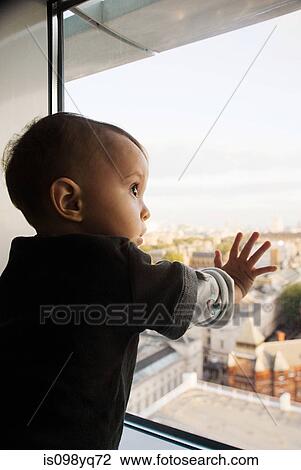 Baby boy touching window View Large Photo Image Stock Image - Baby boy touching window. Fotosearch