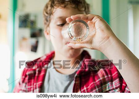 Stock Image - Boy finishing glass of juice. Fotosearch