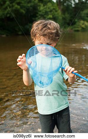 Boy peering into fishing net View Large Photo Image Stock Image - Boy peering into fishing net. Fotosearch