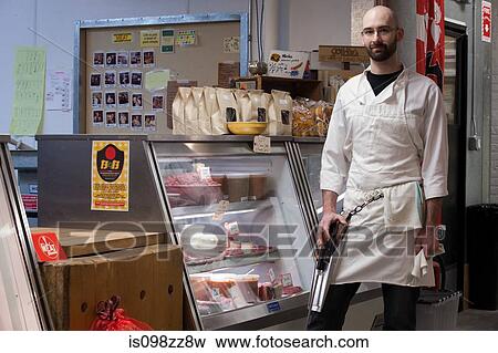Butcher by counter of shop View Large Photo Image Stock Photo - Butcher by counter of shop. Fotosearch