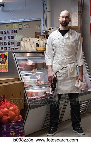 Butcher by counter of shop View Large Photo Image Stock Photo - Butcher by counter of shop. Fotosearch