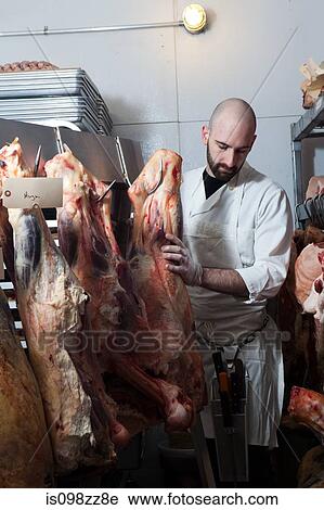 Stock Image - Butcher hanging beef. Fotosearch