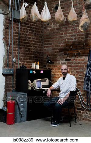 Butcher in office with hams View Large Photo Image Stock Photo - Butcher in office with hams. Fotosearch