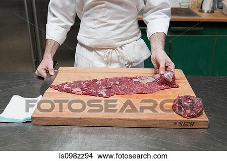 Butcher preparing beef tenderloin View Large Photo Image Picture - Butcher preparing beef tenderloin. Fotosearch