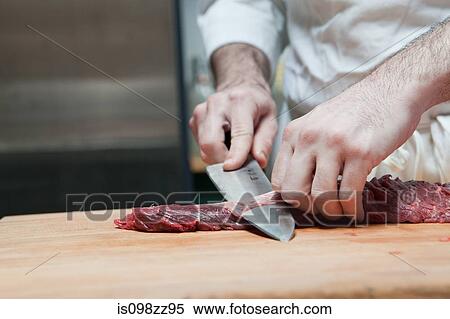 Stock Photography - Butcher preparing beef tenderloin. Fotosearch