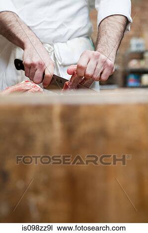Butcher preparing pork ribs View Large Photo Image Stock Image - Butcher preparing pork ribs. Fotosearch