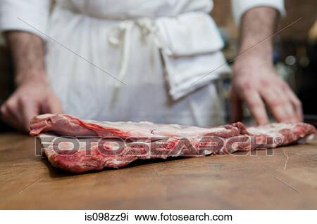 Butcher with pork ribs View Large Photo Image Stock Image - Butcher with pork ribs. Fotosearch