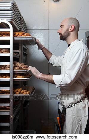 Butcher with racks of sausages on trays View Large Photo Image Picture - Butcher with racks of sausages on trays. Fotosearch