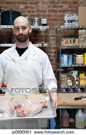 Butcher with tray of meat View Large Photo Image Stock Image - Butcher with tray of meat. Fotosearch