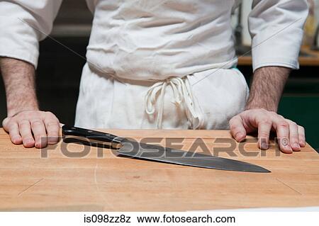 Close up of butcher with chopping board and knife View Large Photo Image Stock Photo - Close up of butcher with chopping board and knife. Fotosearch