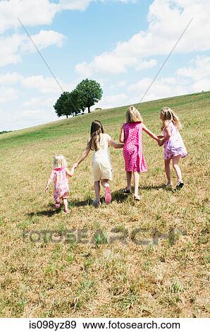 Four girls walking in field View Large Photo Image Stock Photo - Four girls walking in field. Fotosearch