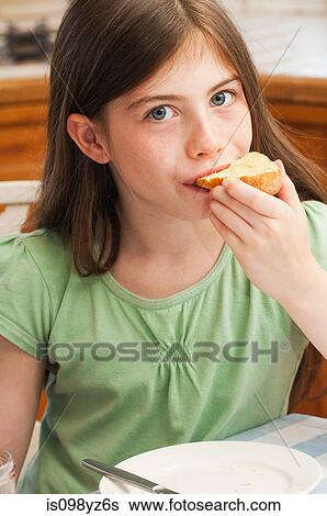 Girl eating croissant View Large Photo Image Stock Photograph - Girl eating croissant. Fotosearch