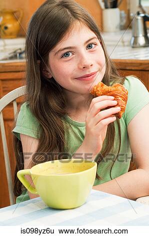 Girl eating croissant View Large Photo Image Stock Photograph - Girl eating croissant. Fotosearch