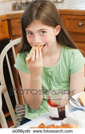 Stock Photography - Girl eating croissant. Fotosearch