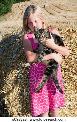 Stock Image - Girl holding cat, portrait. Fotosearch
