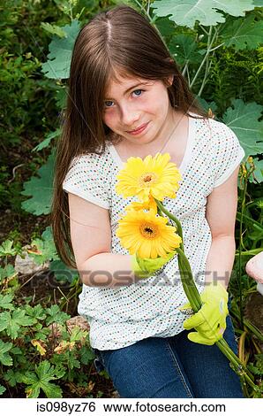Stock Photograph - Girl holding yellow flowers. Fotosearch