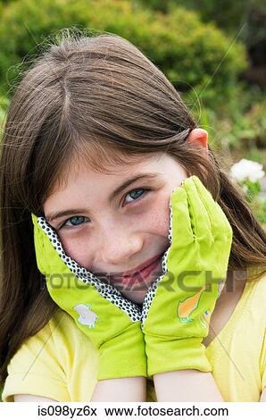 Stock Photo - Girl wearing gardening gloves, portrait. Fotosearch