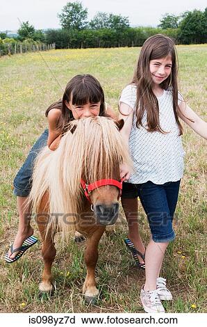 Girls with pony in field View Large Photo Image Stock Image - Girls with pony in field. Fotosearch