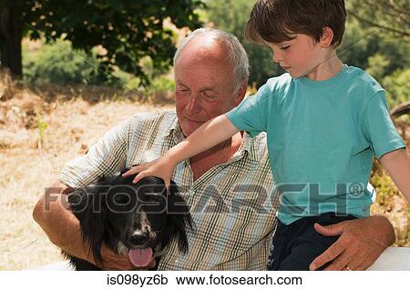 Grandfather with grandson patting dog View Large Photo Image Stock Image - Grandfather with grandson patting dog. Fotosearch