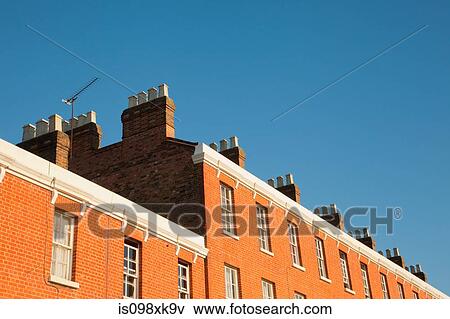 Stock Photo - House exteriors against blue sky. Fotosearch