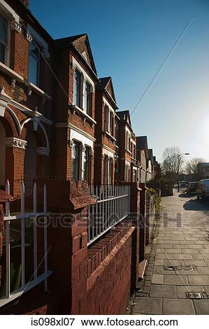 Stock Photo - House exteriors against blue sky. Fotosearch