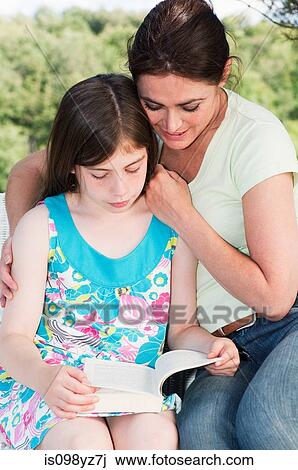 Stock Image - Mother and daughter reading book. Fotosearch