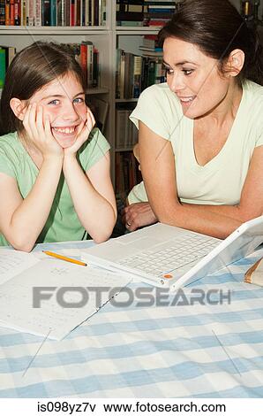 Mother helping daughter with homework View Large Photo Image Stock Photo - Mother helping daughter with homework. Fotosearch