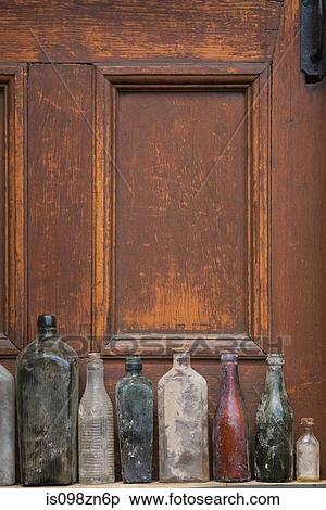 Old glass bottles in a row View Large Photo Image Stock Photography - Old glass bottles in a row. Fotosearch