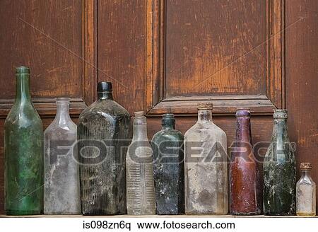 Old glass bottles in a row View Large Photo Image Stock Photography - Old glass bottles in a row. Fotosearch
