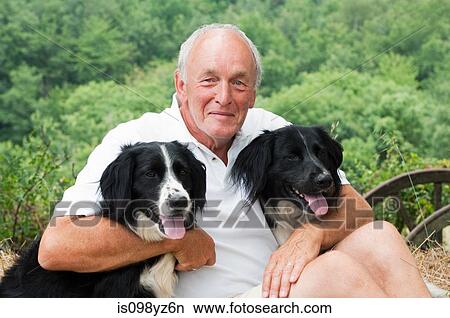 Senior man holding two dogs, portrait View Large Photo Image Picture - Senior man holding two dogs, portrait. Fotosearch
