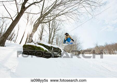 Snowboarder jumping in midair View Large Photo Image Stock Photograph - Snowboarder jumping in midair. Fotosearch