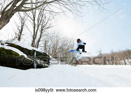 Stock Photograph - Snowboarder jumping in midair. Fotosearch